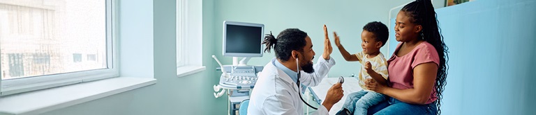 A pediatrician giving a child a high five