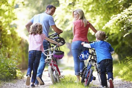 Parents and children walking their bikes