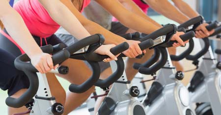 close up of people biking on stationary bikes at a gym