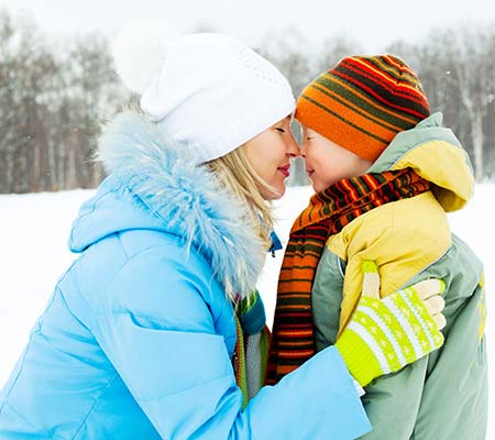 Mother and son nose to nose outside in winter