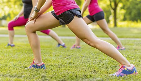 Three runners stretching their calf muscles