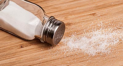 Salt shaker tipped over with salt spilling out instead of healthy salt substitutes
