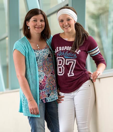 Smiling mother and daughter in walkway