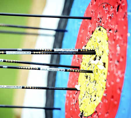 archery target with many arrows in the bullseye