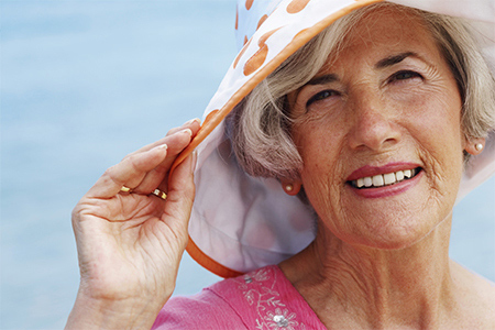 woman protecting her skin with sunhat