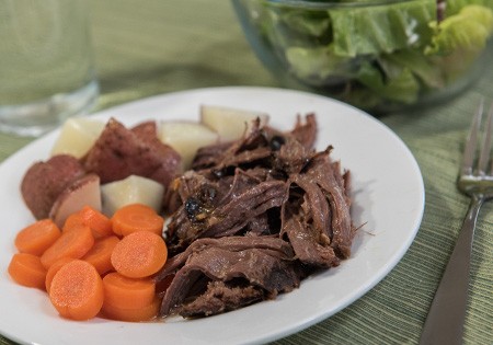 plate of venison, carrots and red potatoes, with a salad on the side