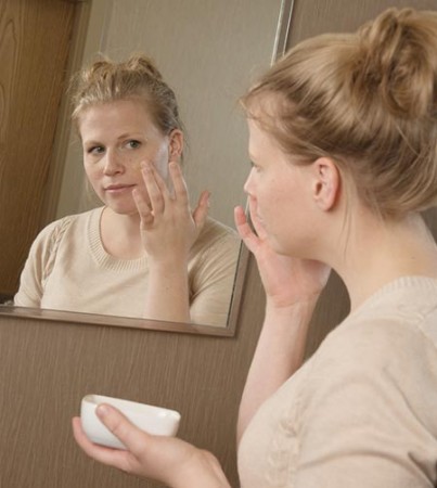 Woman applying face mask