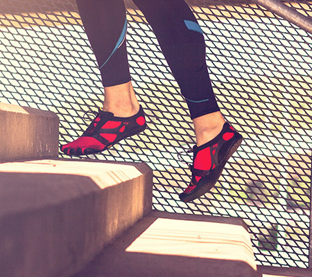 Feet in minimalist shoes running up stairs