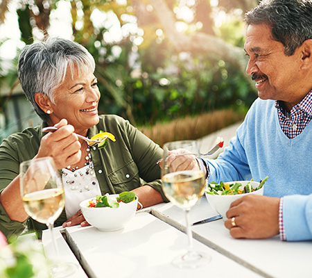 Senior woman eating salad on the patio - Food to reduce joint pain