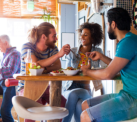 group of friends enjoying a meal at a bar and grill restaurant / making healthy choices in restaurants