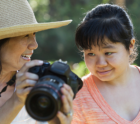 Mother and child looking at photographs on digital camera together - Understanding autism