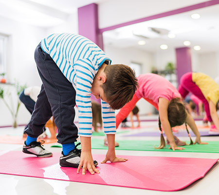 Kids in gym class doing yoga - W-sitting and joint flexibility in kids