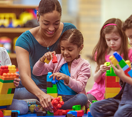 Young children and teacher playing with building blocks - How building toys boost creativity
