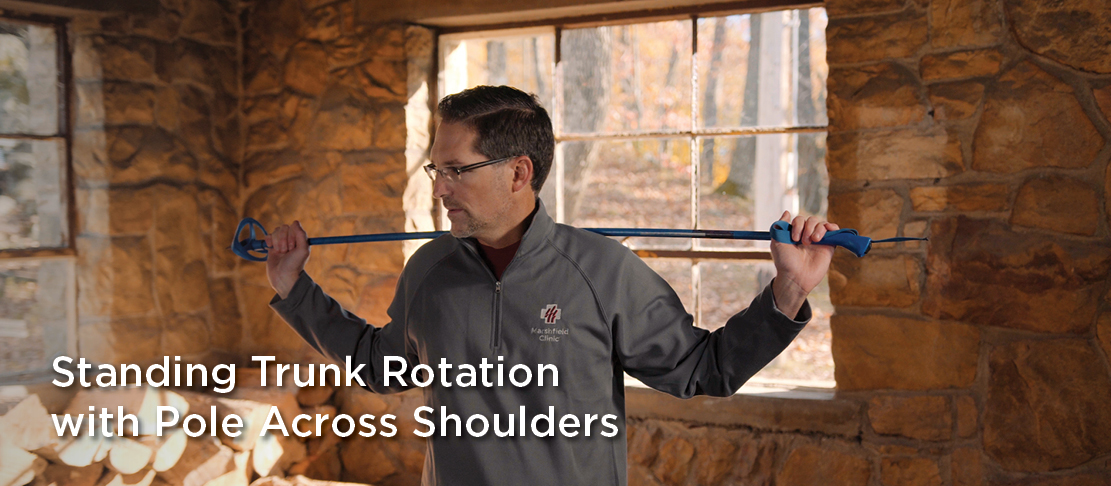 standing trunk rotation with pole across shoulders warmup before exercise