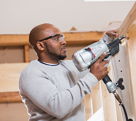 Man using tools for construction, working overhead - Tips for preventing rotator cuff injuries