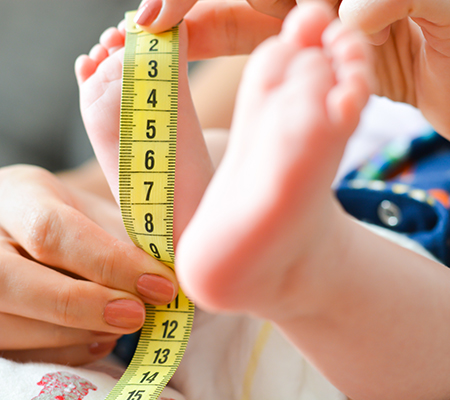 Nurse measuring a baby's foot - What do growth charts mean?
