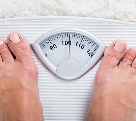Person standing on a scale - Risks of being underweight
