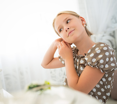Adolescent girl putting in her earrings - Taking care of piercings