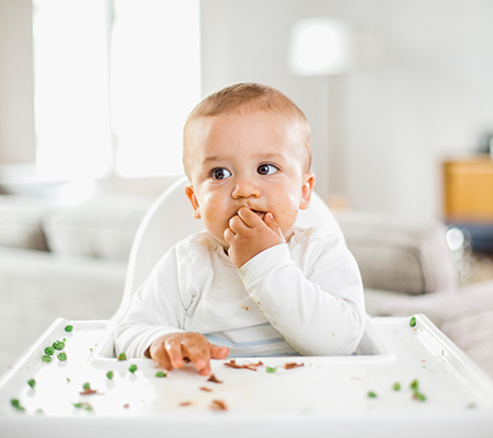 Baby in a high chair eating peas - Object stuck in my child's nose