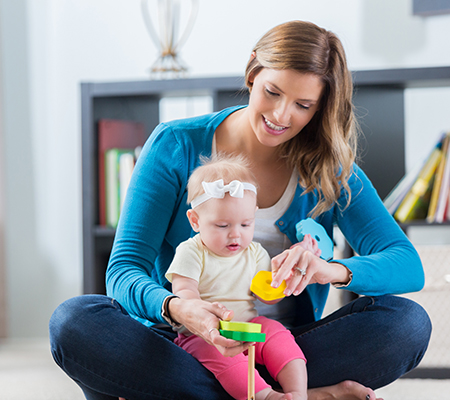 Babysitter and baby playing with toys - What your babysitter should know