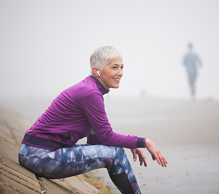Senior woman enjoying a run on the beach - CoolSculpting, what to expect
