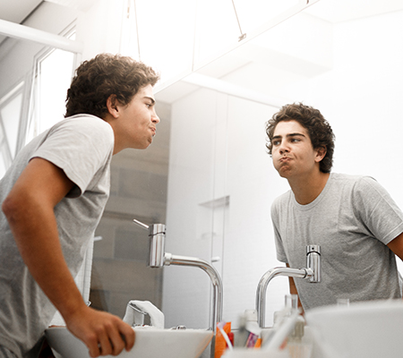 Teenage boy using mouthwash - Oil pulling trend