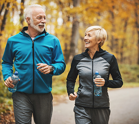 Senior man and woman out for a jog in fall - Heart attacks in women