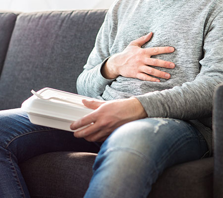 Man eating takeout lunch - Heartburn drugs and cancer risk: Proton pump inhibitors