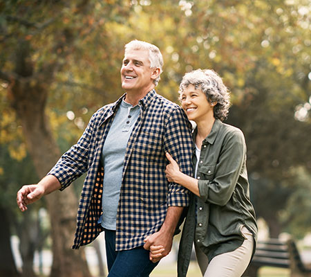 Senior couple walking in a park - Exercise for coronary heart disease
