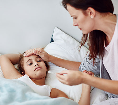 Girl with a fever in bed - What is Kawasaki disease?