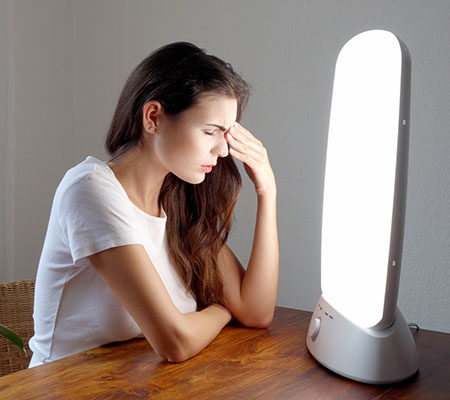 women sitting in front of a light to help with seasonal affective disorder