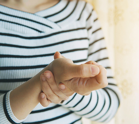Woman holding her wrist - Rheumatoid arthritis
