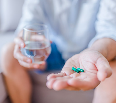 Person with pills in their hand - Antibiotic resistance and kids