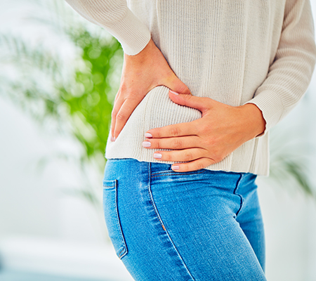 Woman bracing her hip - Hip pain and hip bursitis