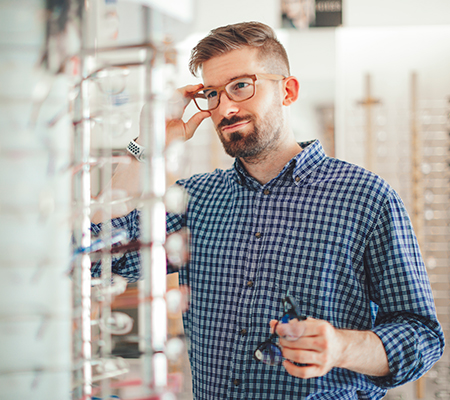 Man choosing glasses at a store - Opticians help you select the right glasses