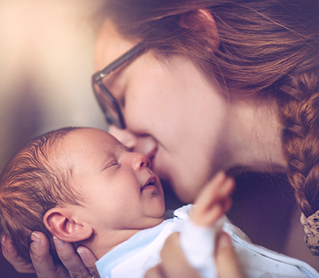 Mother kissing newborn baby - Donating breast milk
