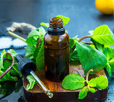 Photo of an essential oil with leaves around it