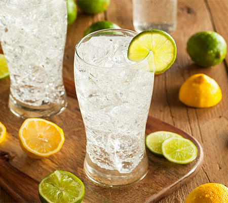 Photo of carbonated water in a glass with lemon and lime