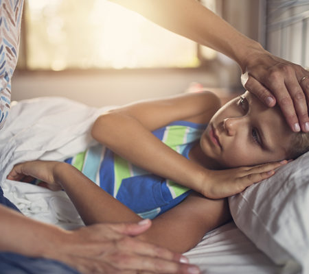 Photo of a young boy sick in bed. 