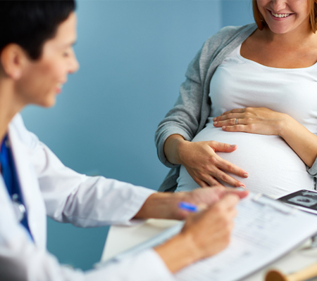 Photo of a pregnant women talking to her provider
