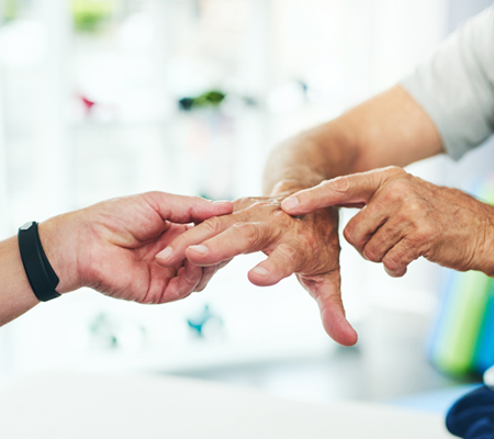 A doctor examines a hand for psoriatic arthritis