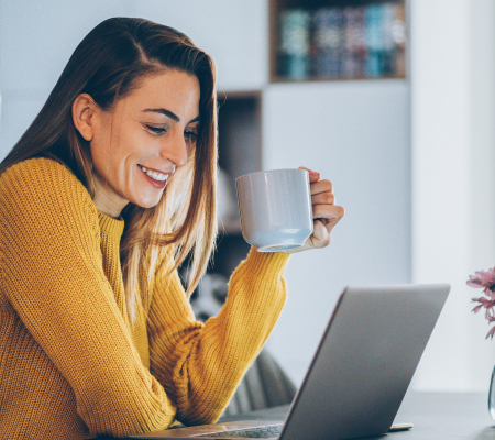 A woman works on a laptop computer from home.