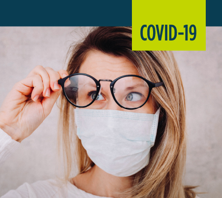 woman looking through glasses with mask on