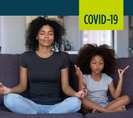 A woman and her daughter meditate.
