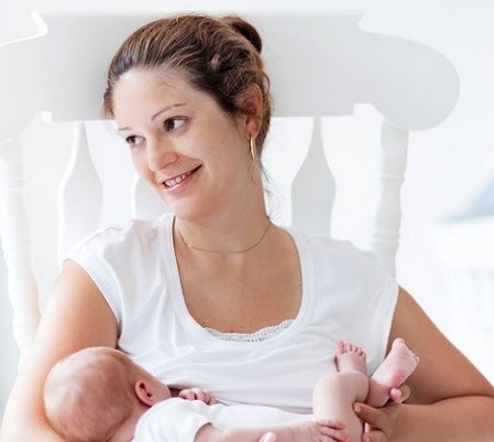 Image of smiling mother holding her baby