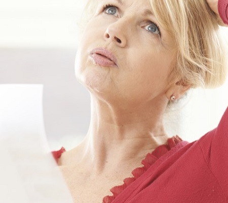 Older woman reading a piece of paper and wondering about something
