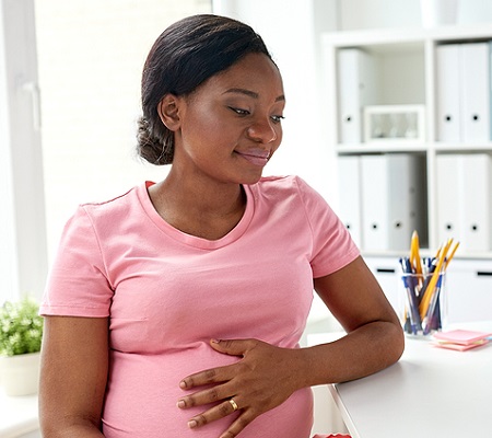Gynecologist doctor writing prescription and pregnant african american woman at hospital 