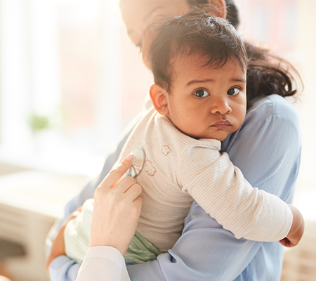 Mother holding her baby with RSV at a doctor's office