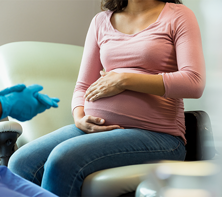 Pregnant woman holding her belly as she hears news about trisomy 13 or an extra 13th chromosome