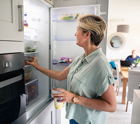 Women opening her refrigerator and grabbing food